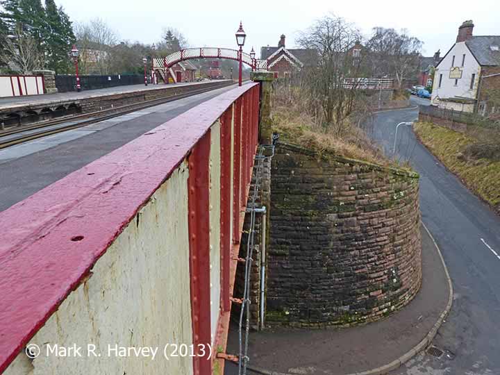 The southwestern side girder and curved wingwall of Bridge SAC/237, with Appleby Station beyond.