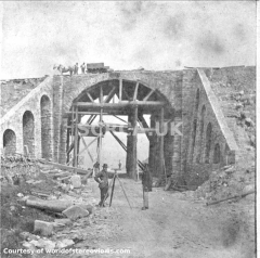 Moorcock Bridge under construction with surveyor & others posing for photo.